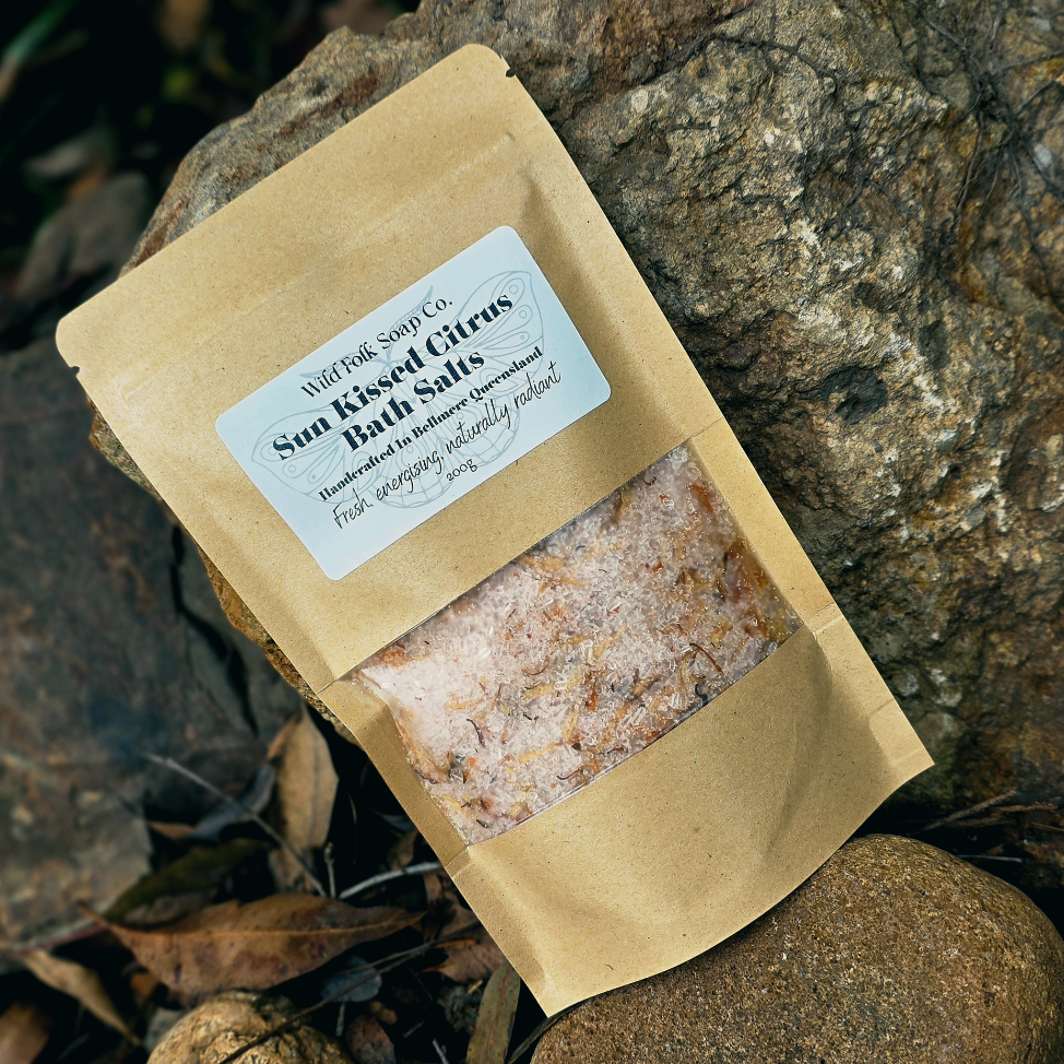 Packaged bath salts with a label on a stone surface