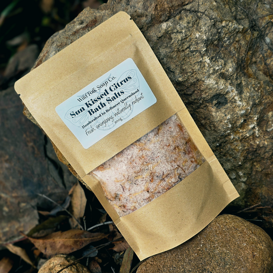 Packaged bath salts with a label on a stone surface