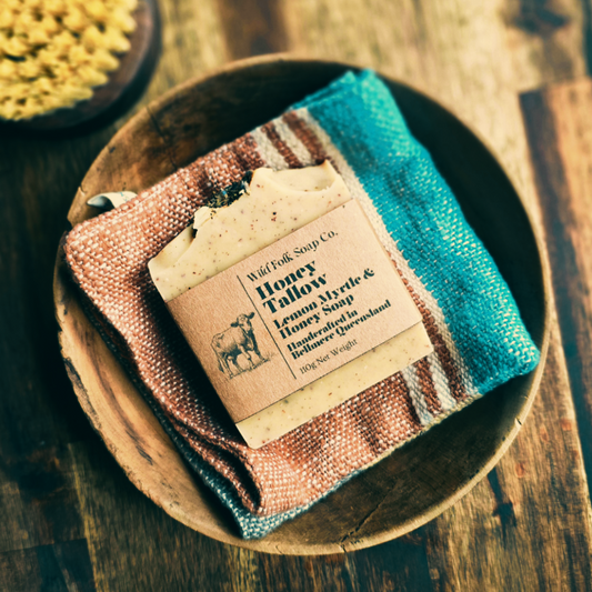 Bar of soap with a label on a wooden plate on a wooden surface