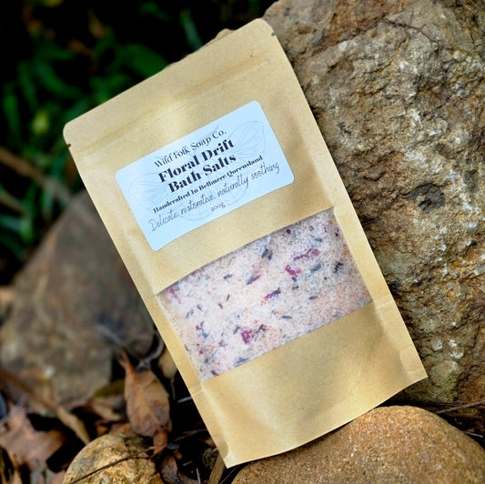 Bag of Wild Folk Soap Co. Floral Drift Bath Salts on a stone surface with greenery in the background