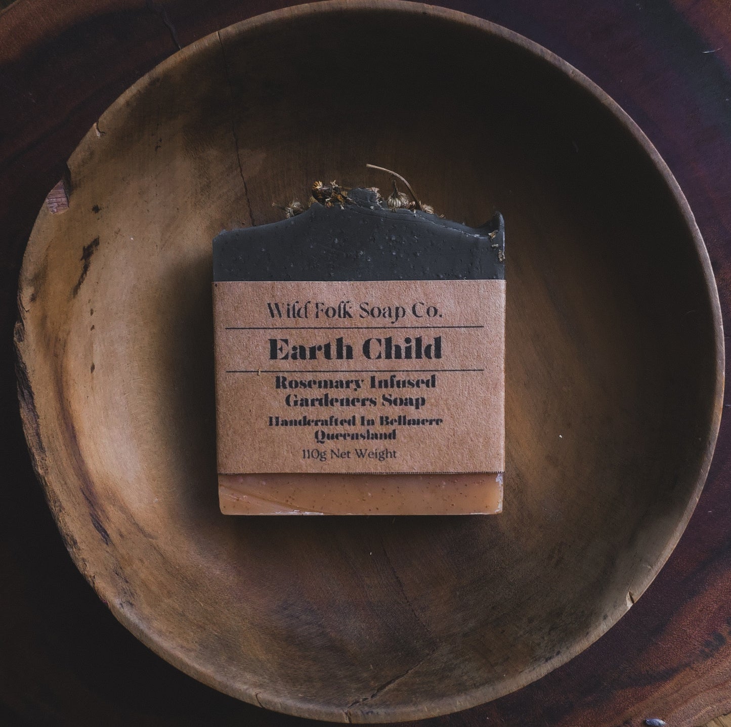 Earth Child handmade cold process gardener's soap with walnut shell, rosemary-infused olive oil, French green clay and peppermint essential oils by Wild Folk Soap Co. on a rustic wooden surface.