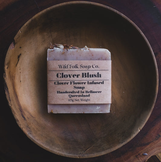 Clover Blush handmade cold process soap with red clover infusion, French pink clay, rose petals and pure essential oils by Wild Folk Soap Co. on a rustic wooden plate.